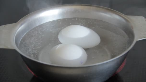 Яйця відварюють у металевій мисці — стокове відео