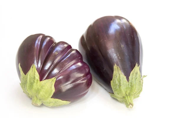 Aubergine op witte achtergrond, een plastic snijplank — Stockfoto