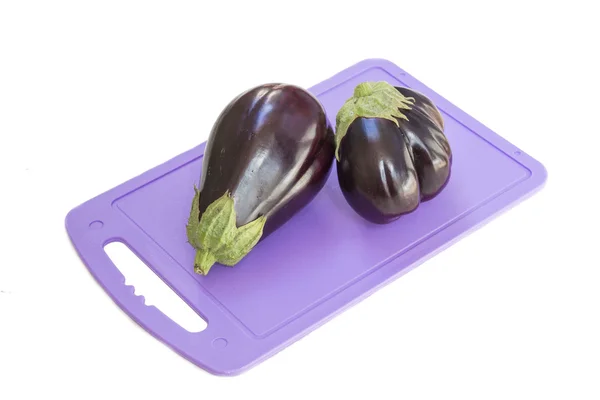 Eggplant on a plastic cutting board, white background — Stock Photo, Image
