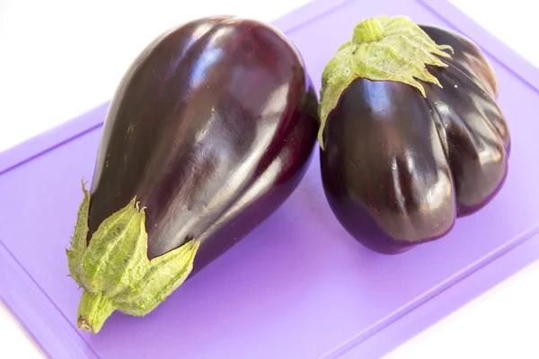 Eggplant on a plastic cutting board, white background — Stock Photo, Image