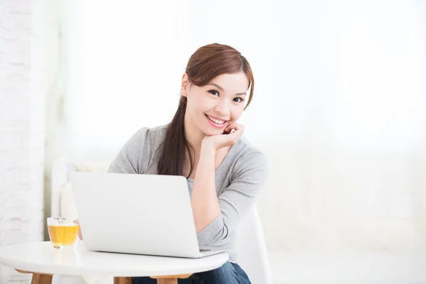 Uśmiechnięta młoda kobieta za pomocą laptopa — Zdjęcie stockowe