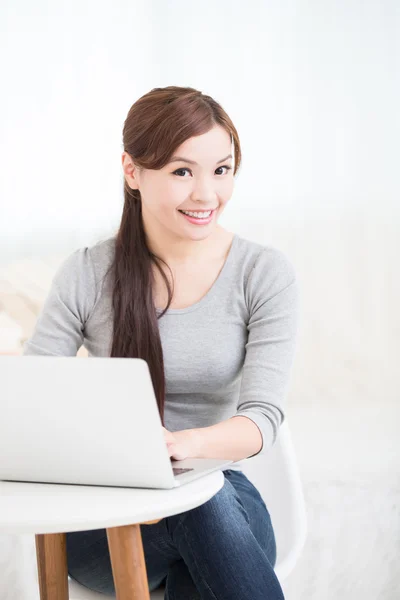 Mulher usando laptop e sorrindo — Fotografia de Stock