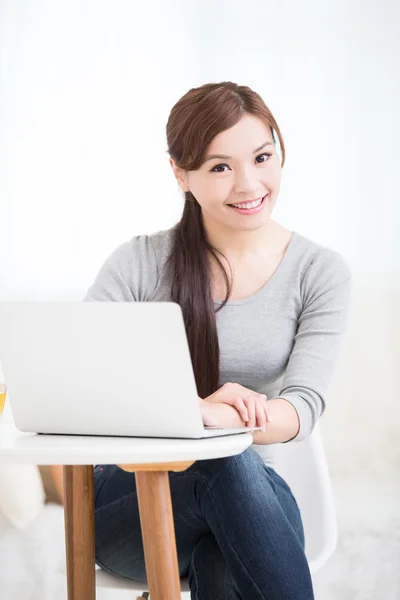 Donna utilizzando computer portatile e sorridente — Foto Stock