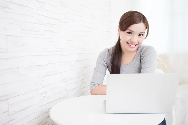 Mujer usando el ordenador portátil y sonriendo —  Fotos de Stock