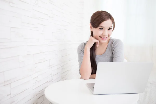 Mulher usando laptop e sorrindo — Fotografia de Stock