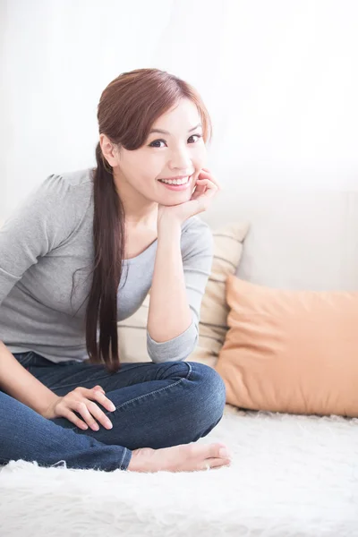 Uśmiech kobieta siedzieć na kanapie — Zdjęcie stockowe