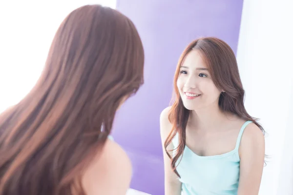 Sonríe mujer mirada espejo — Foto de Stock