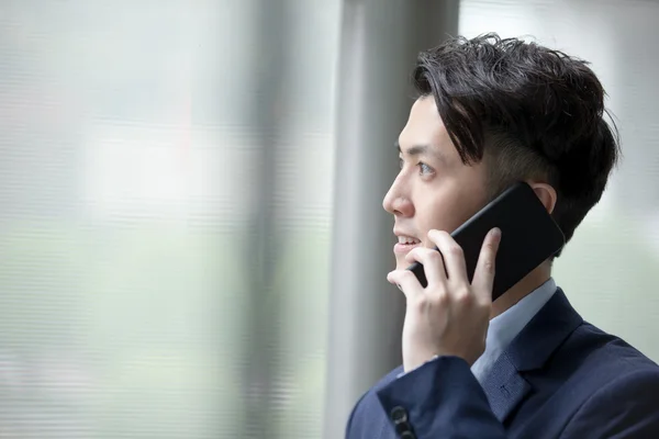 Businessman talking on smart phone — Stock Photo, Image