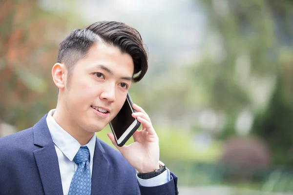 Empresário falando no telefone inteligente — Fotografia de Stock