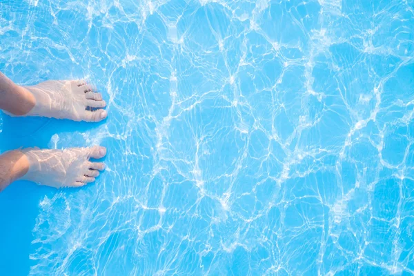 Bare feet in  blue swimming pool — Stock Photo, Image