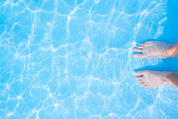 Bare feet in  blue swimming pool — Stock Photo, Image