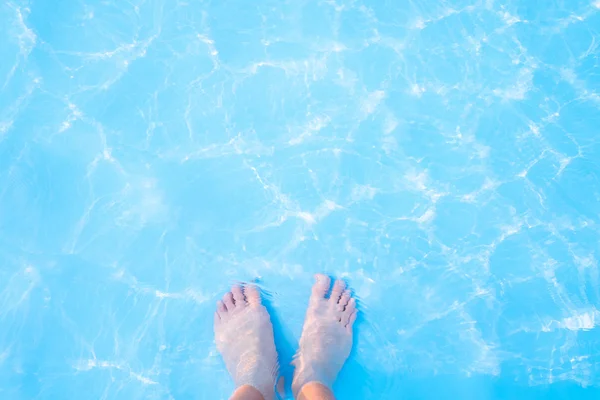 Bare feet in  blue swimming pool — Stock Photo, Image