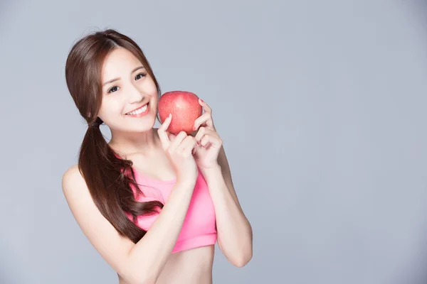 Спортивная девушка с яблоком улыбается — стоковое фото
