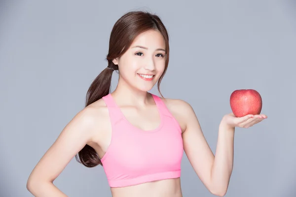 Спортивная девушка с яблоком улыбается — стоковое фото