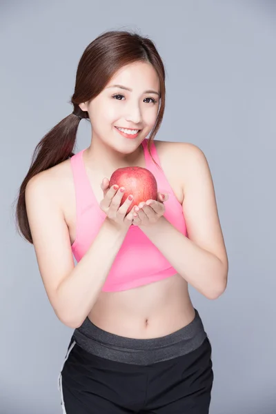 Deporte chica con una manzana sonriendo — Foto de Stock