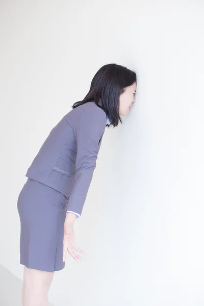 Mujer tocando pared blanca con cabeza — Foto de Stock