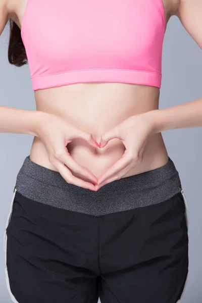 Mãos na barriga formando forma de coração — Fotografia de Stock