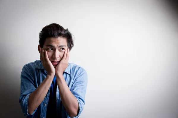 Asian man with hands on face — Stock Photo, Image