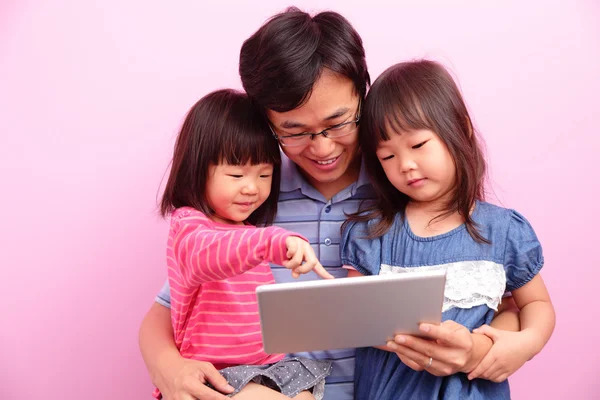 Отец и дочери используют планшет — стоковое фото