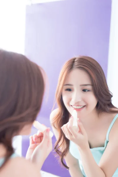 Woman putting   lip balm on lips — Stock Photo, Image