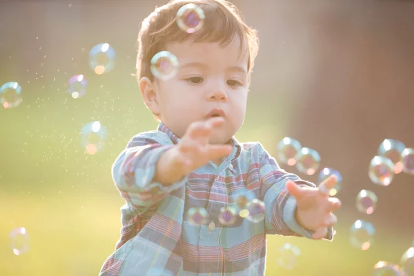 Boy is catching bubbles — Stock Photo, Image