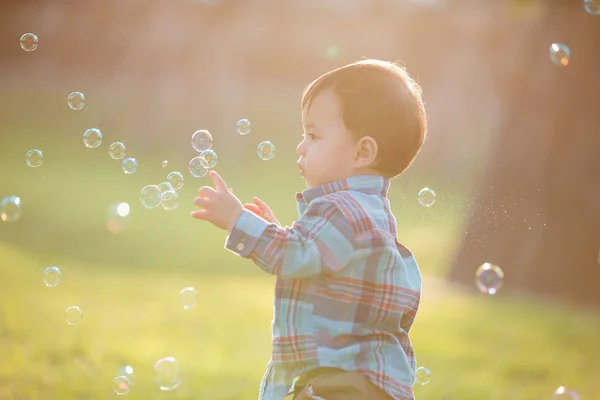Boy is catching bubbles — Stock Photo, Image