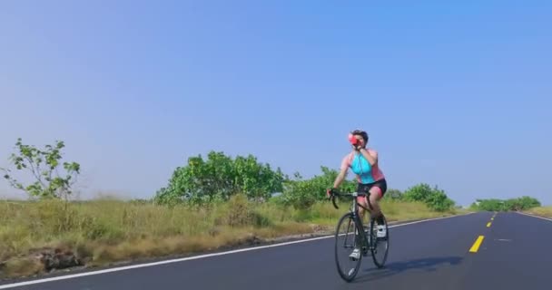 Ασιάτισσα νεαρή γυναίκα καβαλάει ποδήλατο — Αρχείο Βίντεο