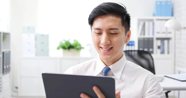 アジアの若いビジネスマンは喜んでオフィスのデジタルタブレットでビデオ通話をしています — ストック写真