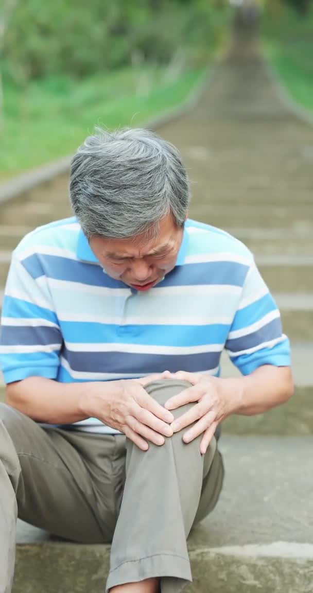 Hombre que sufre de dolor de rodilla — Vídeo de stock