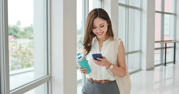 アジアの若い実業家は 都市で通勤中に再利用可能な環境に優しいエコカップとバッグを備えたスマートフォンを使用しています — ストック写真