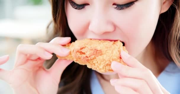Азиатка ест жареную курицу — стоковое видео