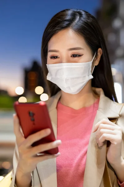 Tett Asiatisk Kvinne Bruker Smarttelefon Utendørs Med Ansiktsmaske Pendling Natten – stockfoto