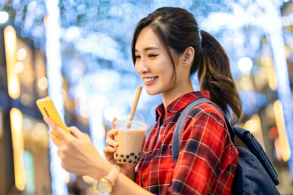 亚洲女性旅行者在台湾度假的时候 晚上用智能手机和珍珠奶茶一起喝茶 — 图库照片