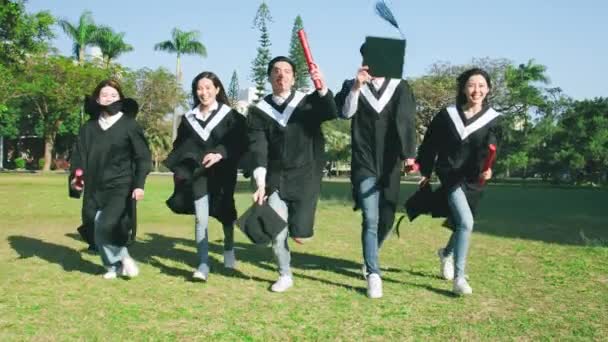 Grup mutlu mezunları şapkalarınızı atın. — Stok video