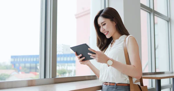 アジアの若い女性は出張中にデジタルタブレットを使い — ストック写真
