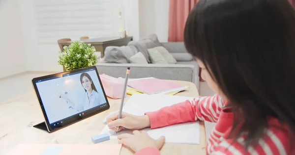 亚洲女孩的侧观是在家里通过数字平板电脑学习英语 看着女教师在网上授课 — 图库照片