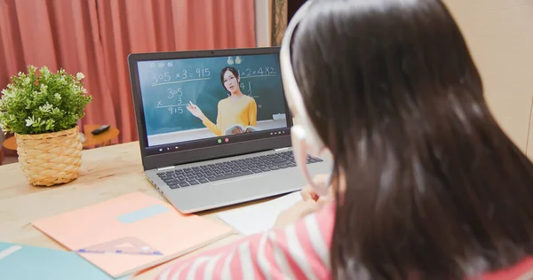 亚洲女孩的后视镜是在家里通过笔记本电脑学习数学 看着小学教师在网上教书 — 图库照片