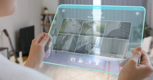 Takaisin Näkymä Aasialainen Nainen Käyttää Kodin Turvakamerajärjestelmä Läpinäkyvä Tabletti Olohuoneessa — kuvapankkivalokuva