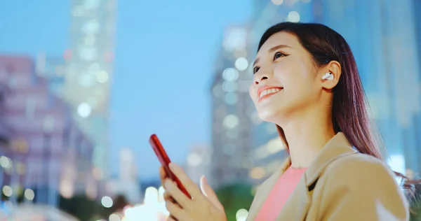 Asian Woman Use Ear Buds Smartphone Outdoor Night While Commuting — Stock Photo, Image