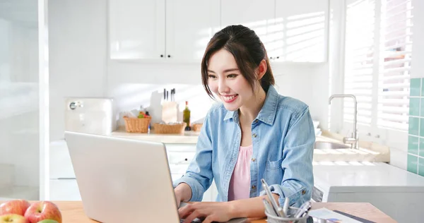 アジアの若い女性は自宅で働くためにラップトップを使用します — ストック写真