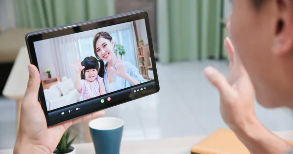 亚洲年轻人在家里开心地通过数码平板电脑与他的妻子和女儿进行视频交谈 — 图库照片
