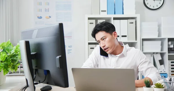 Asiatisk Ung Forretningsmann Snakker Smarttelefon Bruker Datamaskin Til Diskutere Arbeidsplanen – stockfoto