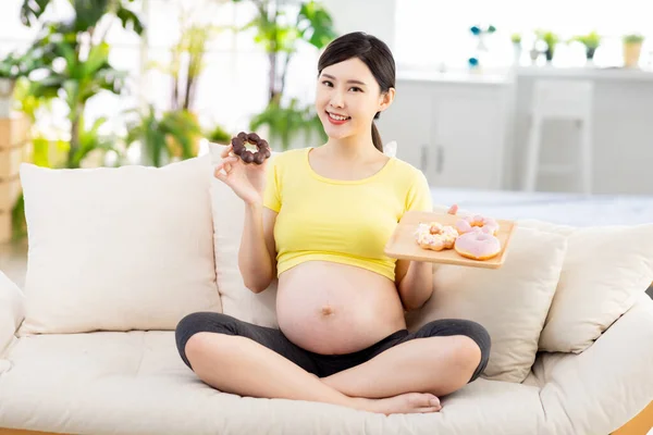 Ongezond Eten Concept Aziatische Zwangere Vrouw Met Donuts Glimlach Woonkamer — Stockfoto