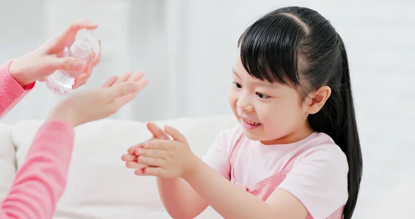 Mom teach child how to wash hands with sanitizer gel in a right way to avoid covid-19 at home