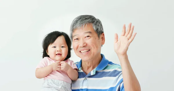 アジアの祖父は彼の赤ん坊の孫娘を抱擁し 喜んで白い背景であなたを見て — ストック写真