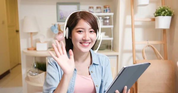 远程办公的概念 亚洲女人带着耳机在家里和数字平板电脑一起参加一个视频会议 — 图库照片