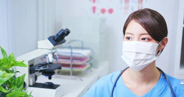 Aziatische Jonge Vrouwelijke Arts Die Draagt Chirurgische Gezichtsmasker Kijkt Ergens — Stockfoto