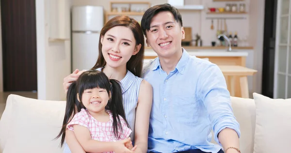 亚洲的年轻夫妇和他们的女儿在家里愉快地通过网络摄像头进行视频聊天 — 图库照片