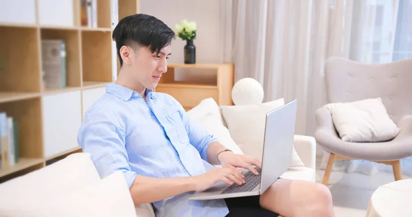 Asiatischer Junger Mann Sitzt Auf Dem Sofa Und Benutzt Laptop — Stockfoto