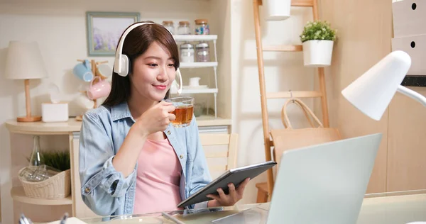 远程办公理念 亚洲女商人头戴耳机 使用笔记本电脑参加视频会议 并在家里喝茶 — 图库照片